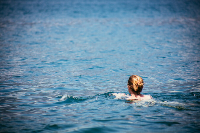 Frau schwimmt in dunkelblauem Wasser