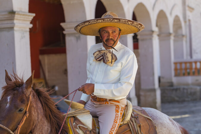 A Very Handsome Mexican Charro Poses In Front Of A Hacienda In The Mexican Countryside