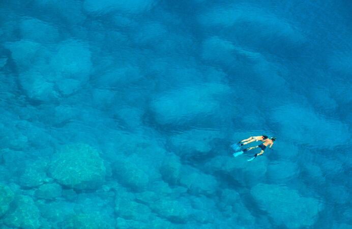 Unidentifiable couple swimming in the Mediterranean Sea in Greece near the island of Lefkas
